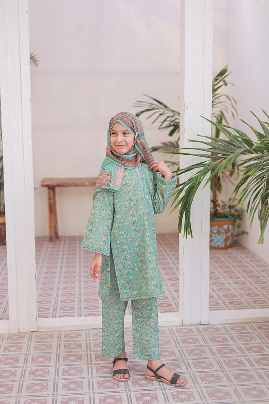 Child wearing a green traditional outfit with a headscarf in a room with white columns and plants.