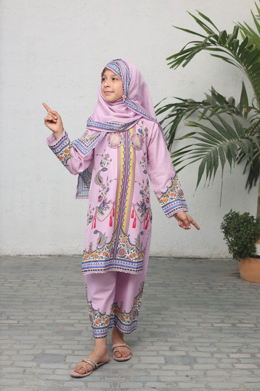 Child wearing a pink traditional outfit with a headscarf, pointing towards the camera.