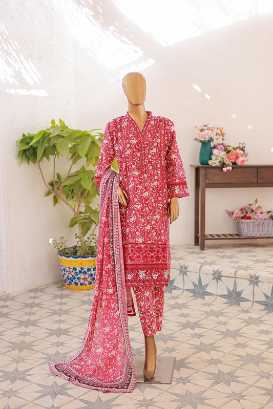 A mannequin displaying a three-piece festive embroidered suit with a red shirt, matching dupatta, and printed trousers, set against a bright background with decorative elements.