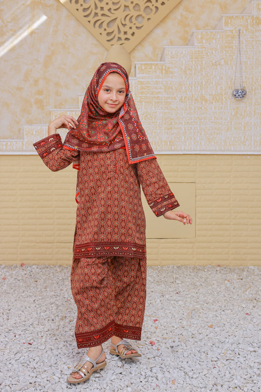 Child wearing a traditional red outfit with a matching headscarf in an indoor setting.