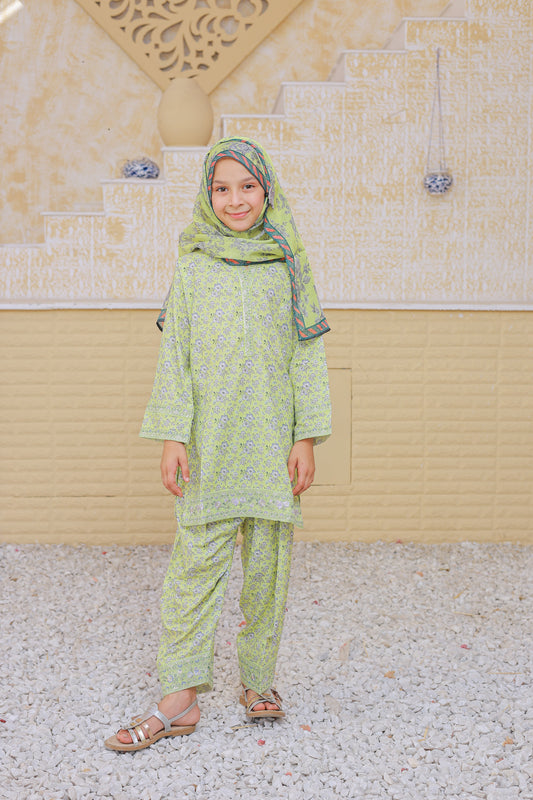 Child wearing a green traditional outfit with a headscarf in a religious setting.