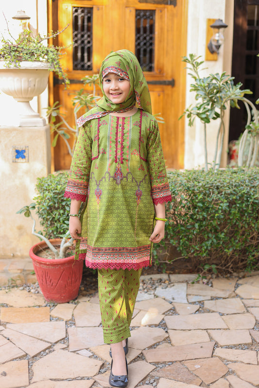 Child wearing a green and pink traditional outfit standing outdoors.