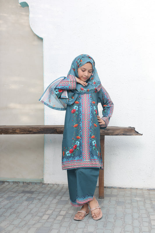 Woman wearing a traditional outfit with a blue dress and headscarf in a minimal indoor setting.