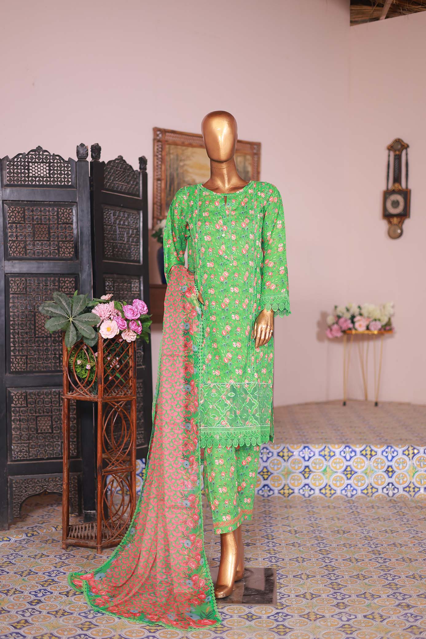 A mannequin displaying a green embroidered shirt with long sleeves, paired with a printed pink dupatta.