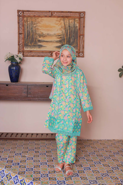 A girl wearing a turquoise embroidered shirt with long sleeves, paired with a matching dupatta and trousers, standing indoors.