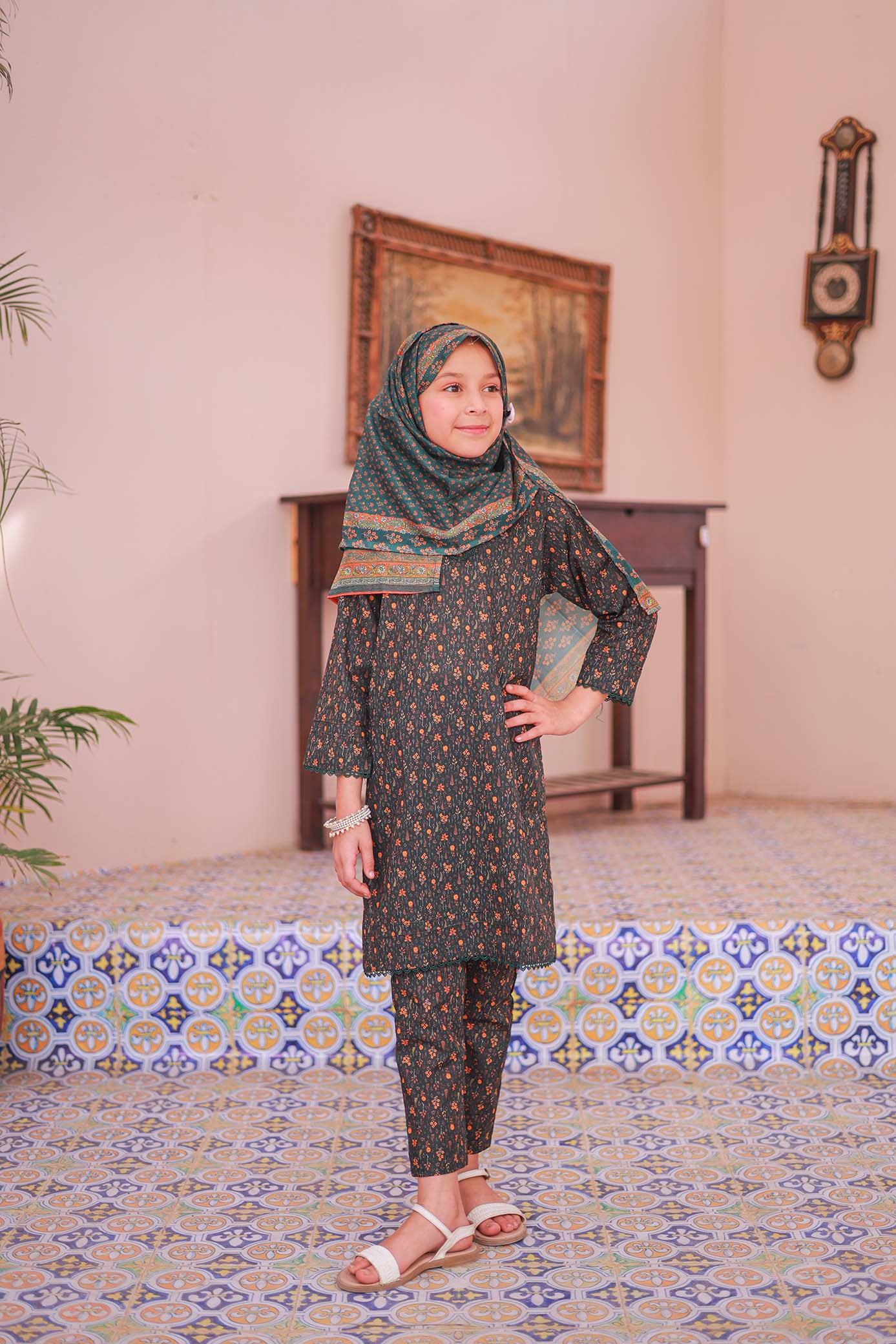 A girl wearing a long-sleeved printed shirt with embellishments, a dupatta, and a matching trouser.